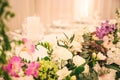 BEAUTIFUL FLORAL DECORATION AT WEDDING TABLE WITH IMPRESSIVE COLOURFUL VENUE AND BLURRED BACKGROUND Royalty Free Stock Photo