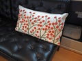 Beautiful floral embroidered pillow on a black sofa