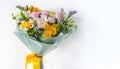 A beautiful flower bouquet is tied with a yellow silk ribbon. White background. Copy space, close up