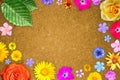 Beautiful flower frame with empty in center on orange hardboard background. Floral composition of spring or summer flowers.