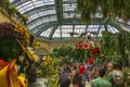 a beautiful flower garden with colorful flowers and people walking at Bellagio Conservatory and Botanical Gardens Royalty Free Stock Photo