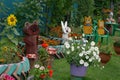 Beautiful flower garden near the house with figures of cute animals