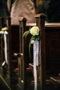 Beautiful flower wedding decoration in a church hang on the seat rows setting in the Chapel, ceremony selective focus Royalty Free Stock Photo