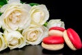 Beautiful flowers on black background with cream roses bouquet with macaroon