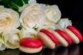 Beautiful flowers on black background with cream roses bouquet with macaroon