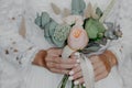 Beautiful Flowers in brides hands. Bridal bouquet. Woman in wedding white dress prepared for wedding ceremony. Selective focus Royalty Free Stock Photo