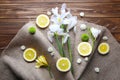 Beautiful flowers and lemon slices with burlap on wooden background