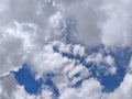Beautiful fluffy white clouds floating in a clear blue sky. Natural and bright cloudscape background for various design projects. Royalty Free Stock Photo
