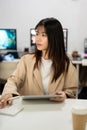 Beautiful, focused Asian businesswoman is working at her desk in the office Royalty Free Stock Photo