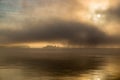 River in the fog, just before sunrise.Warm glow in the clouds from the first sunrays. Royalty Free Stock Photo