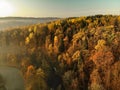 Beautiful foggy forest scene in autumn with orange and yellow foliage. Aerial early morning view of trees and river Royalty Free Stock Photo