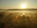 Beautiful foggy forest scene in autumn with orange and yellow foliage. Aerial early morning view of trees and river Royalty Free Stock Photo