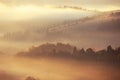 Beautiful foggy landscape in the sunrise mountains. Fantastic morning foggy autumn hills Royalty Free Stock Photo