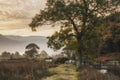 Beautiful foggy misty Autumn sunrise over countryside surrounding Crummock Water in Lake District in England Royalty Free Stock Photo