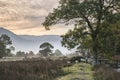 Beautiful foggy misty Autumn sunrise over countryside surrounding Crummock Water in Lake District in England Royalty Free Stock Photo