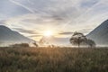 Beautiful foggy misty Autumn sunrise over countryside surrounding Crummock Water in Lake District in England Royalty Free Stock Photo