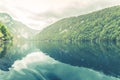 Beautiful foggy morning mountain lake with overcast sky. Vintage filter style. Peaceful nature landscape, tranquil lake water Royalty Free Stock Photo