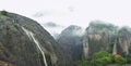 Beautiful foggy mountain view with waterfall and pagoda