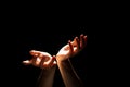 Beautiful folded hands with light on top, black background. Prayer or creating a miracle. Royalty Free Stock Photo