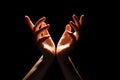 Beautiful folded hands with light on top, black background. Prayer or creating a miracle. Royalty Free Stock Photo