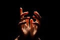 Beautiful folded hands with light on top, black background. Prayer or creating a miracle. Royalty Free Stock Photo