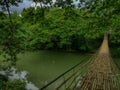 Beautiful footbridge made from bamboo over a river Royalty Free Stock Photo