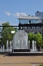 Beautiful fountain in the park. Town square with a fountain and a modern hotel. The inscription in Russian MEGAPOLIS.