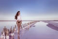 Beautiful free girl in white swimwear posing on salty beach