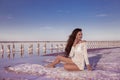 Beautiful free girl in white swimwear posing on salty beach