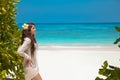 Beautiful free woman enjoying on exotic beach in summer by tropical blue water. Attractive girl with long hair sunbathing and res Royalty Free Stock Photo