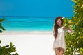 Beautiful free woman enjoying on exotic beach in summer by tropical blue water. Attractive girl with long hair sunbathing and res Royalty Free Stock Photo