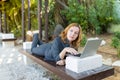 A beautiful freelancer woman works at the park