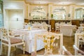 Beautiful french restaurant interior with crystal chandeliers and table seating with china porcelain tableware