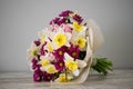 Beautiful fresh Blossoming Bouquet of Narcissus,Carnations, Chrysanthemum in pink and yellow colors on the grey background Royalty Free Stock Photo