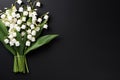 beautiful fresh bouquet of lilies of the valley on black background top view, beautiful floral template with copy space