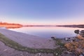 Beautiful, fresh and colorful nature at sunset with calm water near forest. Still, gentle lake against a background of Royalty Free Stock Photo