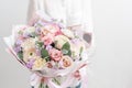 Beautiful fresh cut bouquet of mixed flowers in woman hand. the work of the florist at a flower shop. Delicate Pastel