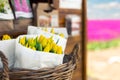 Beautiful fresh cut yellow tulips bouquet wrappped in paper in basket at vintage self servise wooden stall shop self Royalty Free Stock Photo