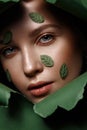 Beautiful fresh girl with perfect skin, natural make up and green leaves. Beauty face. Close up Royalty Free Stock Photo