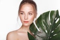 Beautiful fresh girl with perfect skin, natural make up and green leaves. Beauty face. Royalty Free Stock Photo