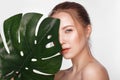 Beautiful fresh girl with perfect skin, natural make up and green leaves. Beauty face. Royalty Free Stock Photo