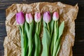 Beautiful fresh tulips with paper on the wooden background