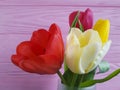 Beautiful fresh tulips vase arrangement on pink wooden, place for text