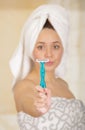 Beautiful fresh young girl with after shower towel holding blue razor Royalty Free Stock Photo