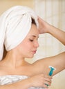 Beautiful fresh young girl with after shower towel holding blue razor shaving armpit underarm