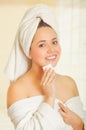 Beautiful fresh young girl wearing white bathrobe removing makeup Royalty Free Stock Photo