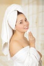 Beautiful fresh young girl wearing white bathrobe removing makeup Royalty Free Stock Photo