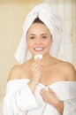 Beautiful fresh young girl wearing white bathrobe removing makeup Royalty Free Stock Photo