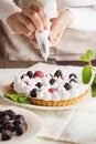 Beautiful freshly made berry meringue tart on plate. Stunning Blackberry meringue pie still life composition. Food photo. Process