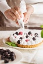 Beautiful freshly made berry meringue tart on plate. Stunning Blackberry meringue pie still life composition. Food photo. Process